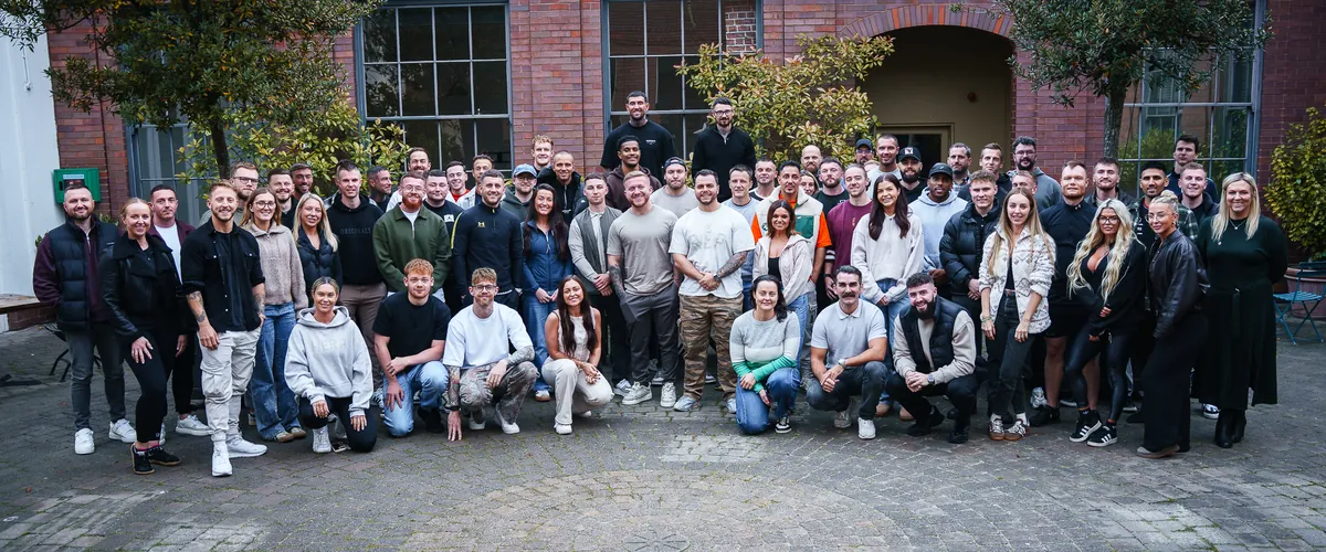 Around seventy Titanom clients and team members together in a courtyard at one of the in-person events